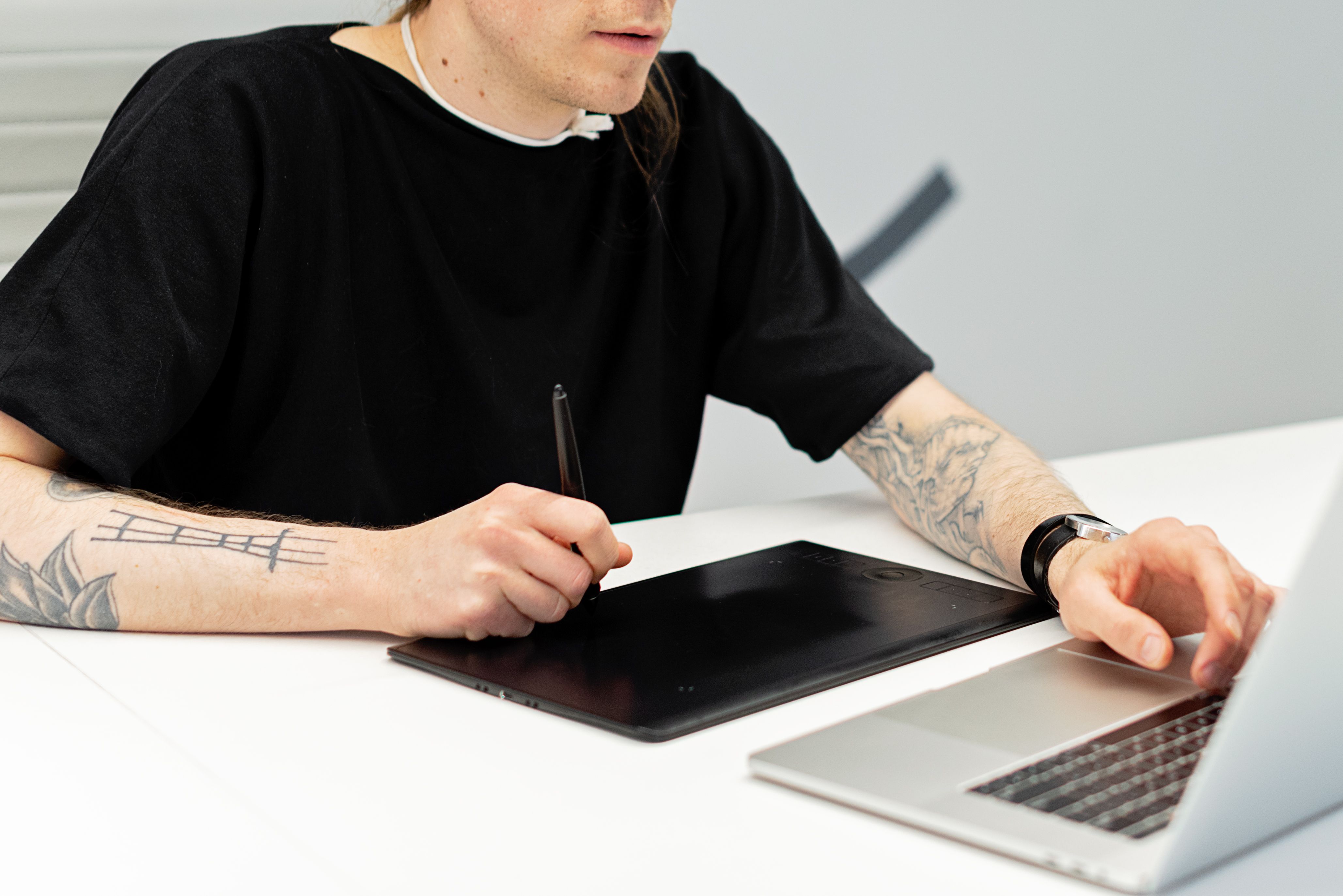 Illustrator working on a graphics tablet and laptop creating digital comic art